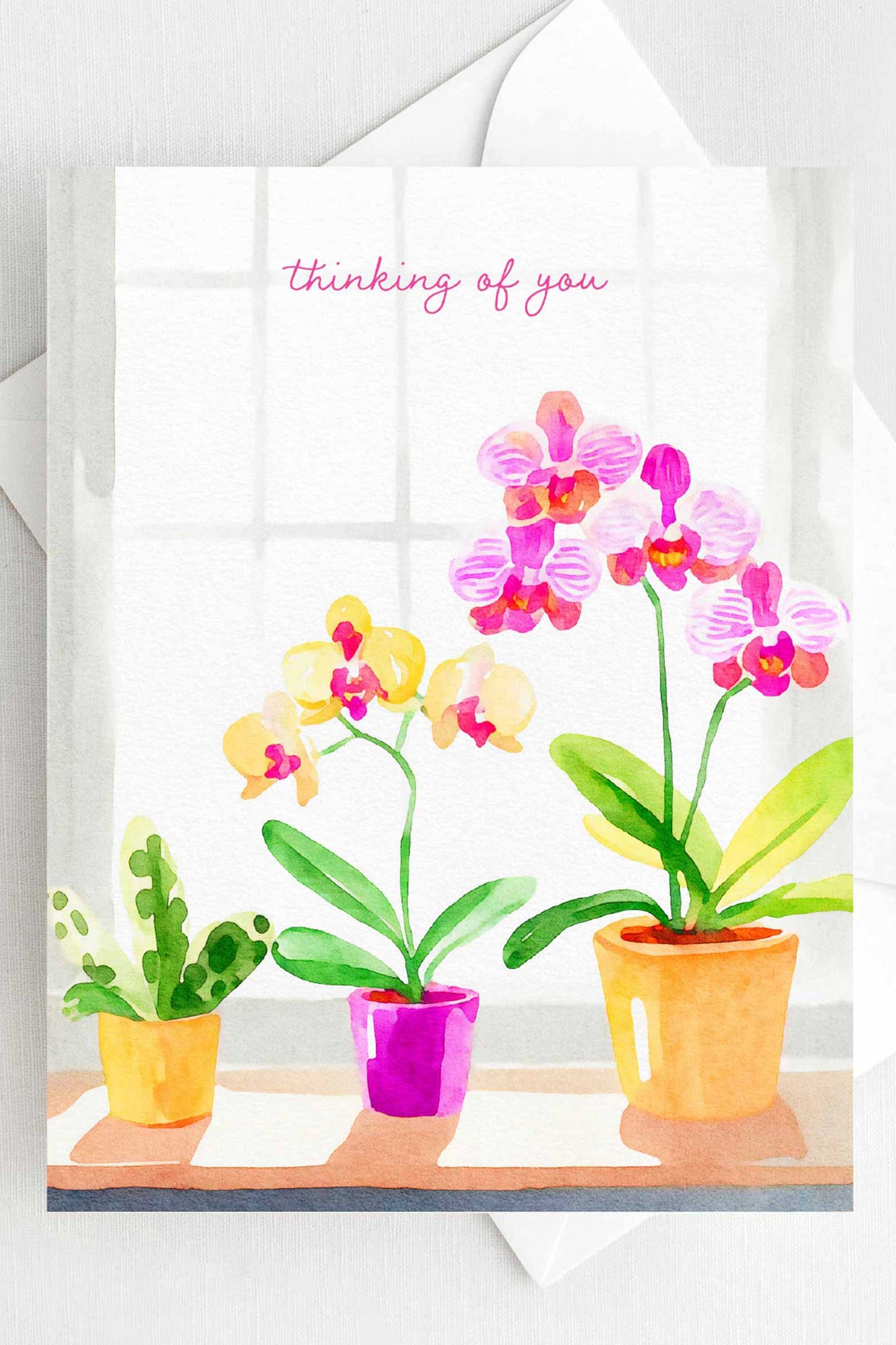 Thinking of You greeting card with watercolor orchids in pink and yellow, A2 size (5.5” x 4.25”), includes a white envelope.