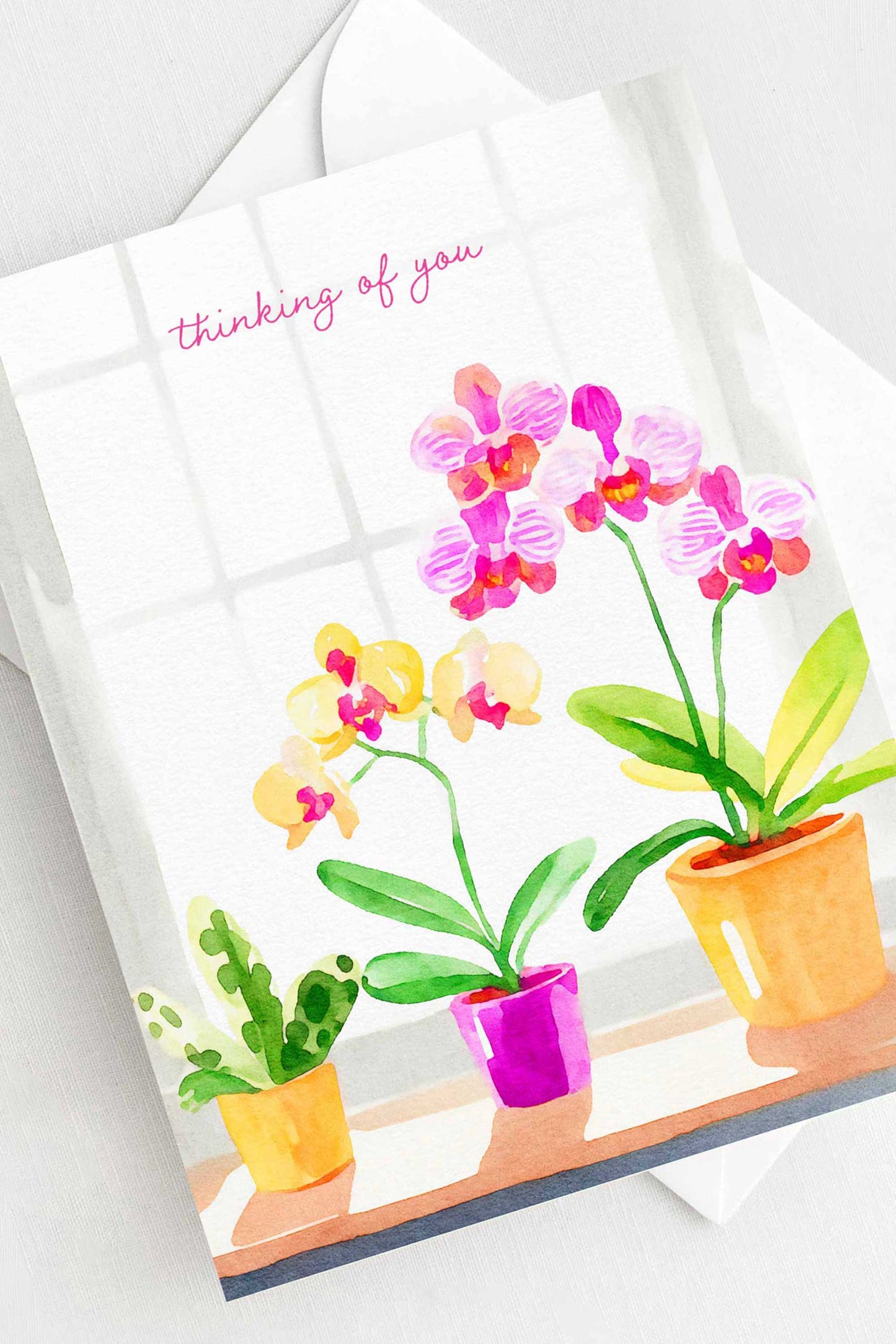 Thinking of You greeting card with watercolor orchids in pink and yellow, A2 size (5.5” x 4.25”), includes a white envelope.