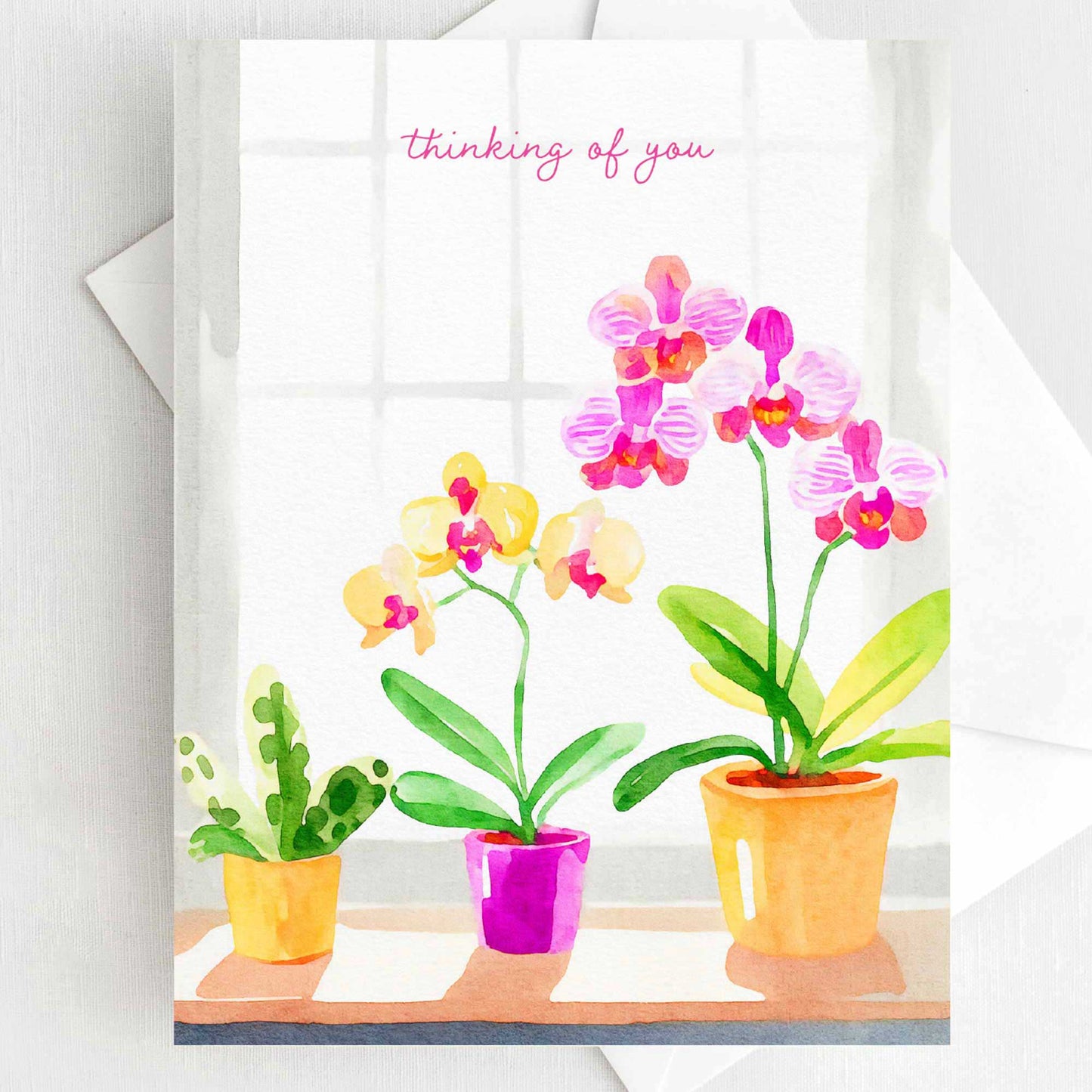 Thinking of You greeting card with watercolor orchids in pink and yellow, A2 size (5.5” x 4.25”), includes a white envelope.